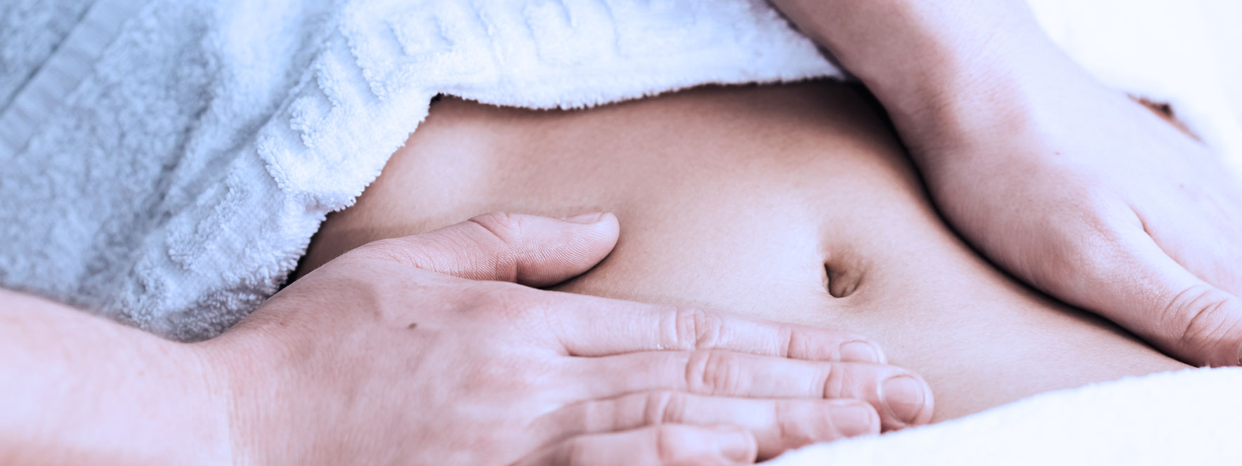 Femme reçoit un massage du ventre afin d'assouplir les adhérences