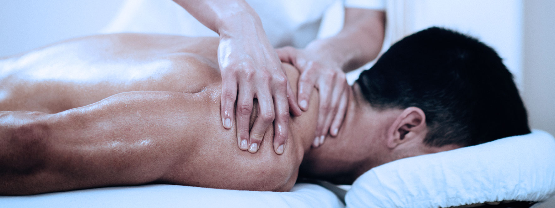 Un homme se fait masser une épaule sur une table de massothérapie